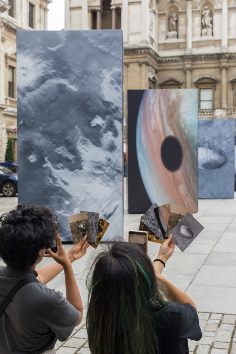 two people discussing the exhibition and looking at the images of mercury and jupiter